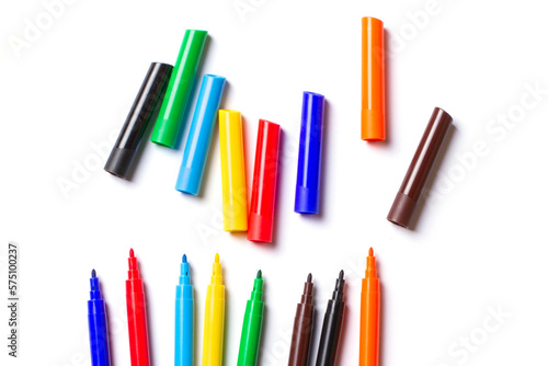 Markers of different colors lie. With open caps. On a white background.