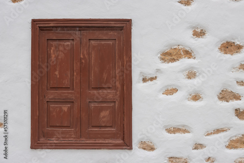 Window and a white facade with stones photo