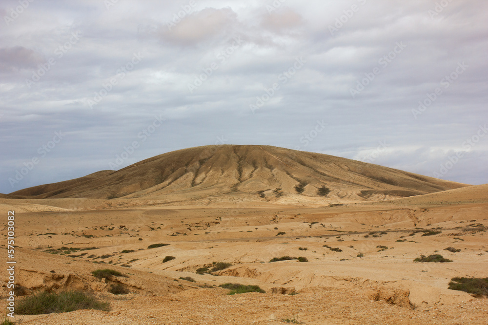 A  vetical photo of a beautiful view of a mountain in the desert of Fuerteventura