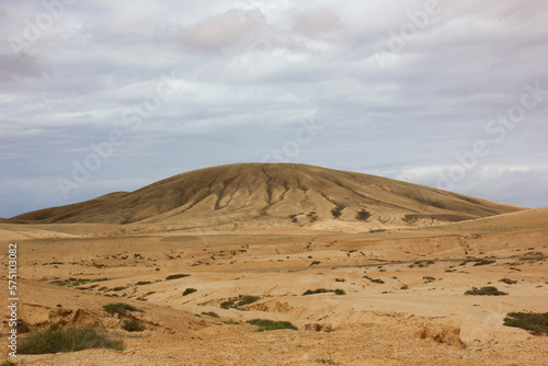 A vetical photo of a beautiful view of a mountain in the desert of Fuerteventura