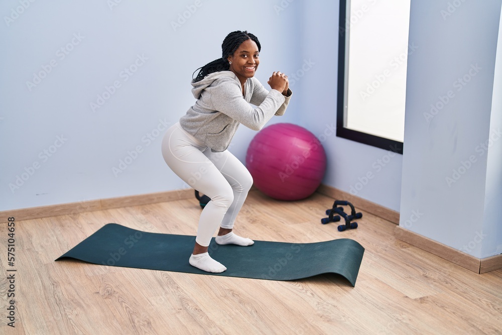 Naklejka premium African american woman smiling confident training legs exercise at sport center