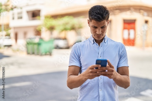 Young hispanic man using smartphone at street © Krakenimages.com