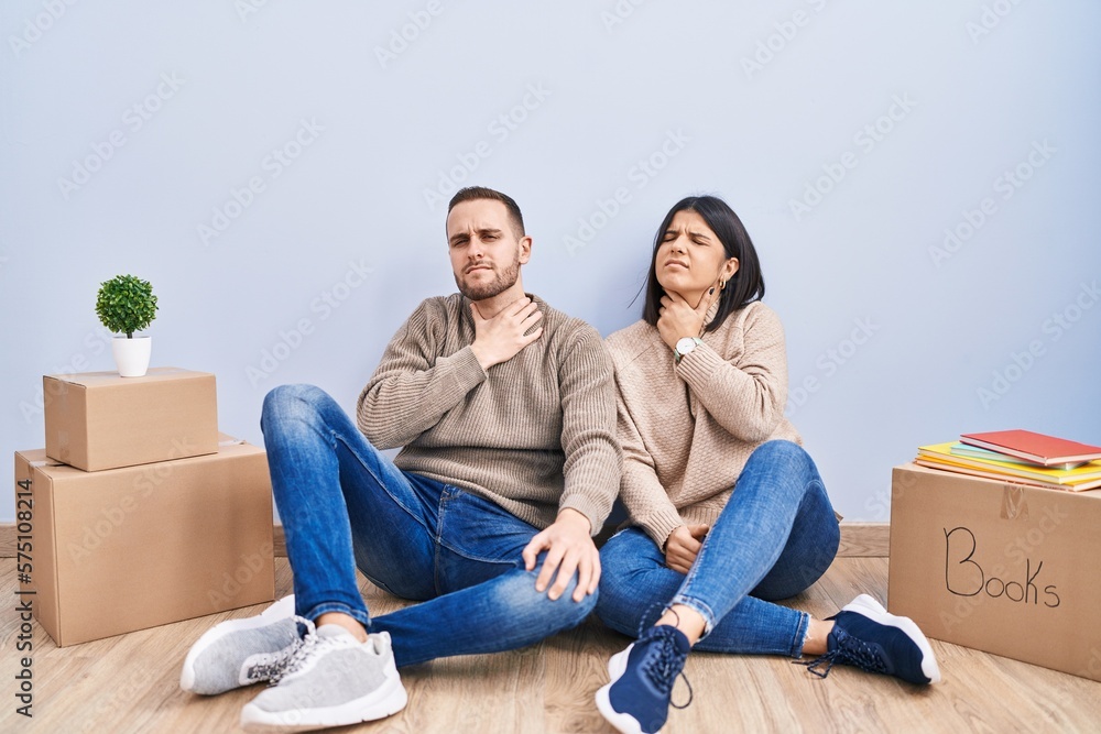 Young couple moving to a new home touching painful neck, sore throat for flu, clod and infection Young couple moving to a new home touching painful neck, sore throat for flu, clod and infection
