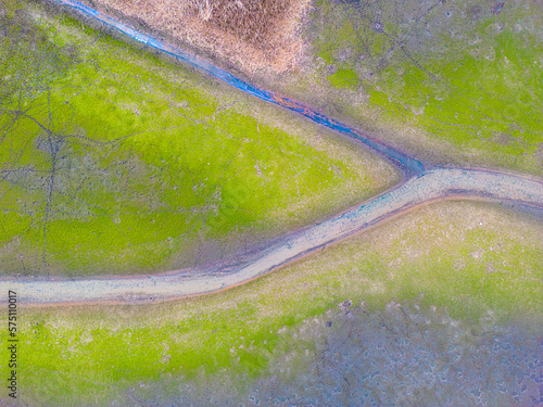Fototapeta Naklejka Na Ścianę i Meble -  An aerial shot of the landscape with small lake surrounded by trees and field