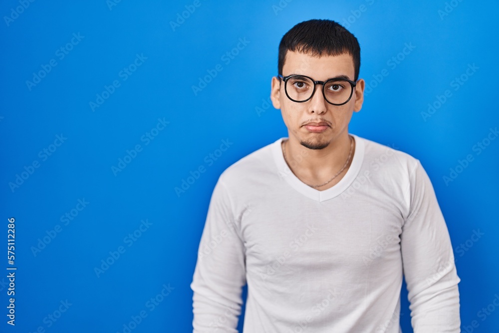 Young arab man wearing casual white shirt and glasses depressed and worry for distress, crying angry and afraid. sad expression. Young arab man wearing casual white shirt and glasses depressed and worry for distress, crying angry and afraid. sad expression.