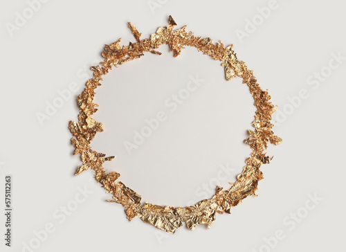 Gold (bronze) glitter empty circle frame on beige gray paper background. Abstract copy space texture.