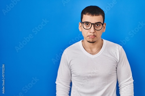 Young arab man wearing casual white shirt and glasses depressed and worry for distress, crying angry and afraid. sad expression.