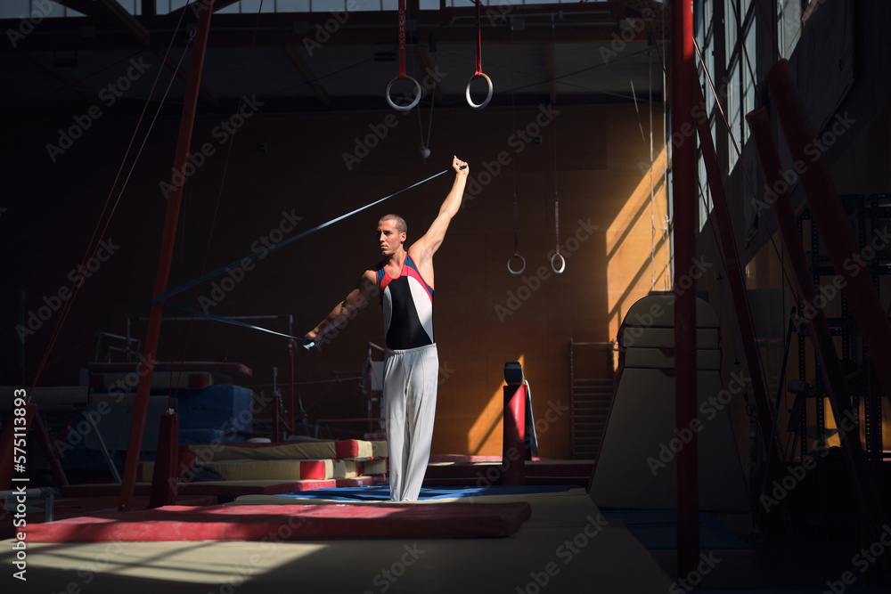 Young sports gymnast stretching with a rubber band in the gymnasium
