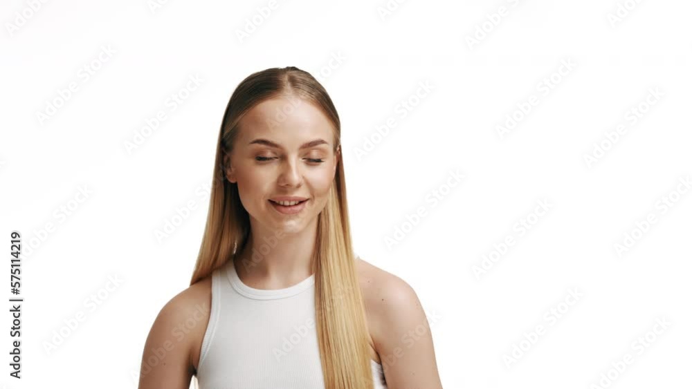 A luxurious blonde combs her long hair. Blonde girl smiling on a white background with a comb. A luxurious blonde combs her long hair. Blonde girl smiling on a white background with a comb.