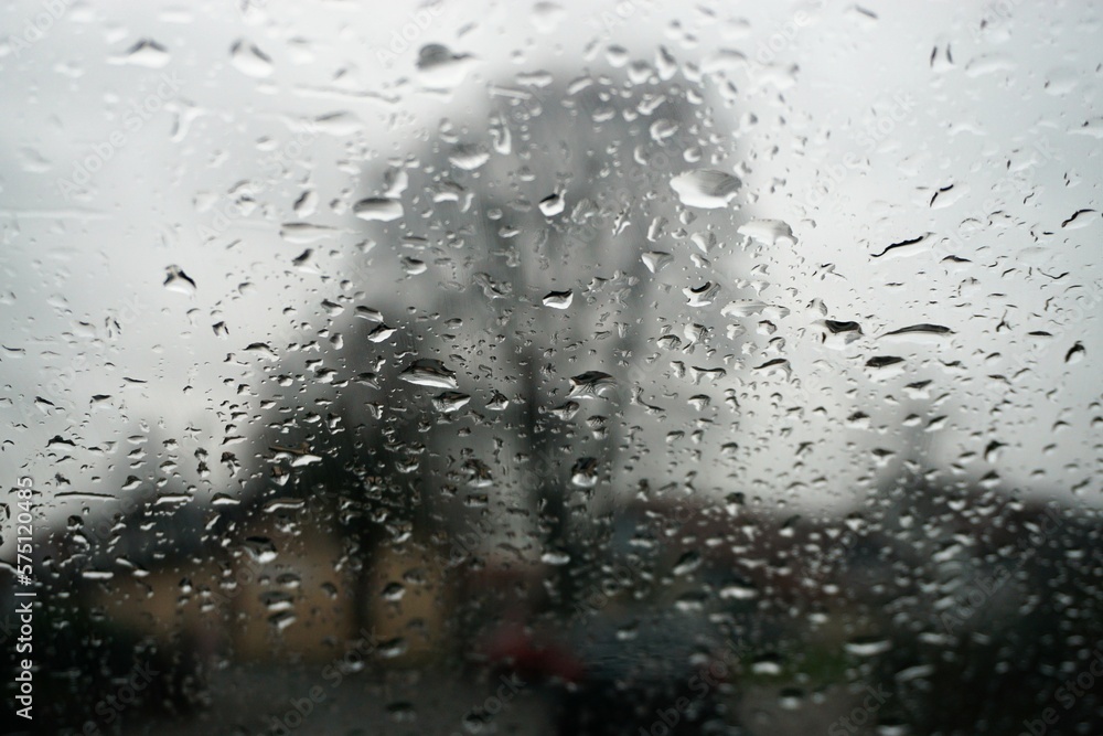 Abstraktes Motiv mit Glasscheibe mit Regentropfenmuster vor bäumen, Häusern und grauem Himmel bei Regen am Morgen im Winter Abstraktes Motiv mit Glasscheibe mit Regentropfenmuster vor bäumen, Häusern und grauem Himmel bei Regen am Morgen im Winter