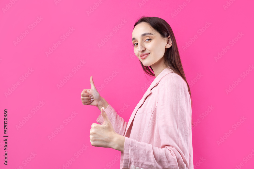 Happy young caucasian female in an pink jacket making thumb up sign and smiling. Good job and respect. Happy young caucasian female in an pink jacket making thumb up sign and smiling. Good job and respect.