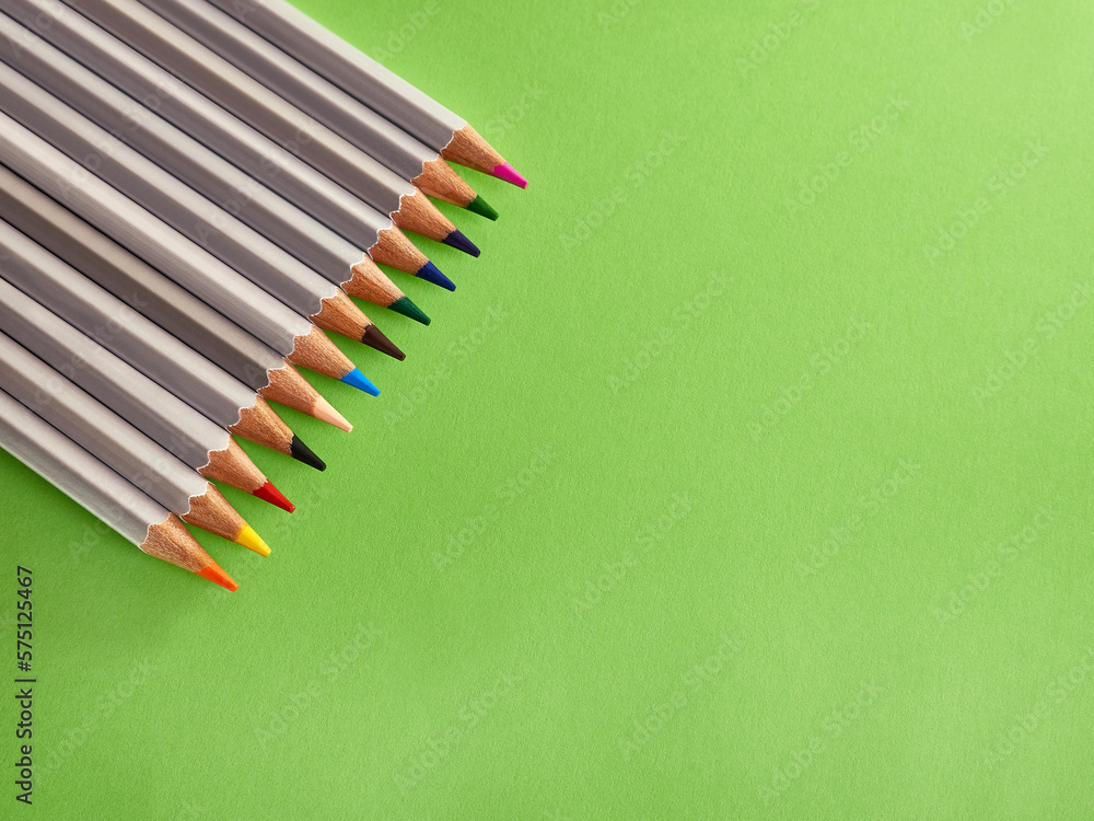 A set of colored pencils on a green background. Stationery for creativity and learning. A set of colored pencils on a green background. Stationery for creativity and learning.