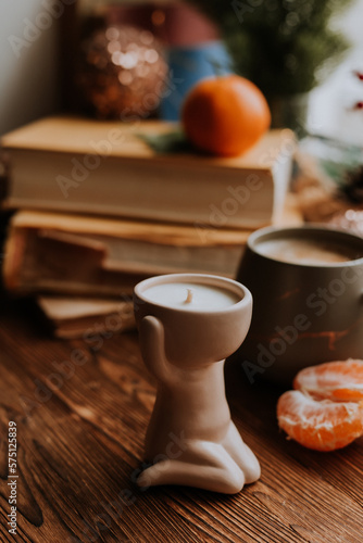 handmade scented candles, coffee, books and tangerines for the New Year. Cozy atmosphere of Christmas at home