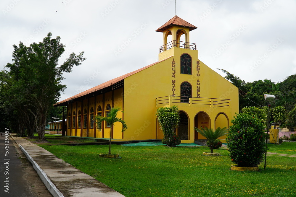 Naklejka premium Yellow orange catholic church in the small town of Novo Airao in rural Amazonas. State of Amazon, Northern Brazil.