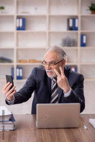 Old male employee working in the office