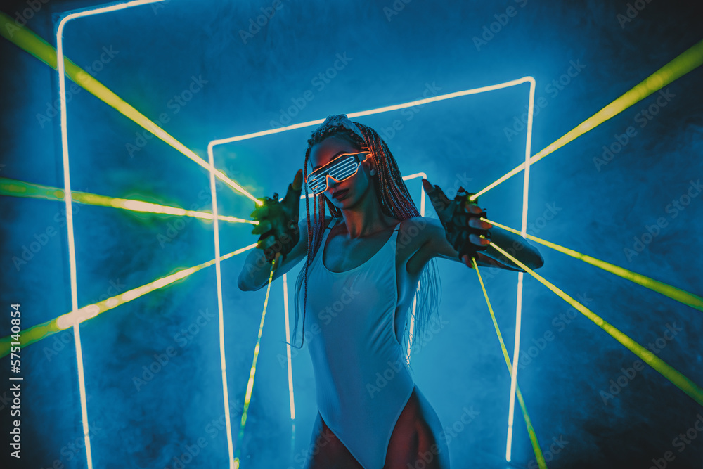 Young woman dancer posing in dark night club interior with blue lights green lasers - obrazy, fototapety, plakaty 