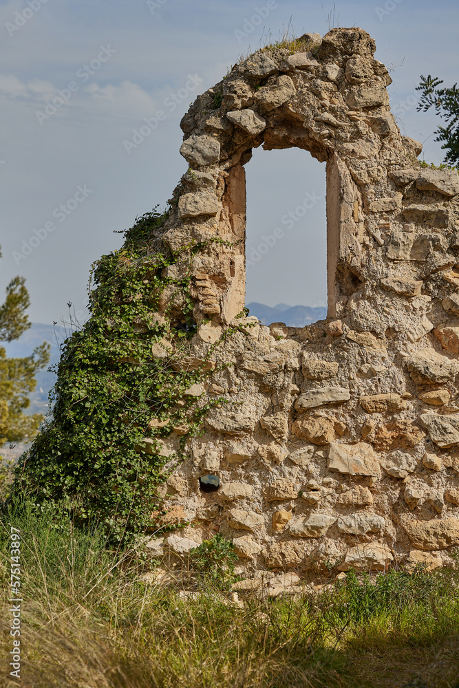 Ruined walls of an ancient castle with a window on a rock
