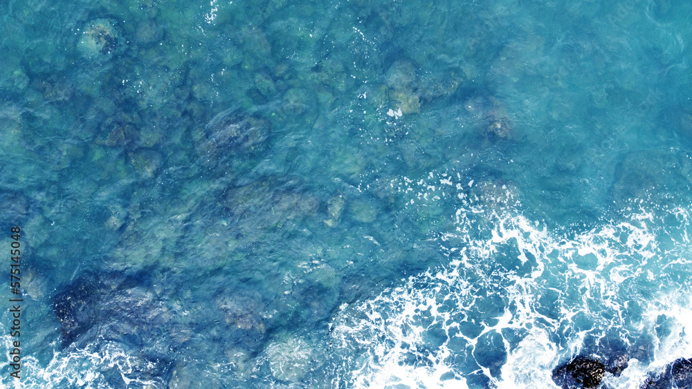 Fototapeta premium Aerial view of the ocean water surface and waves. Beautiful water background texture for tourism and advertising. Tropical coast