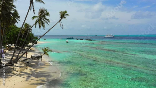 Aerial: Beautiful View Of Tropical Trees On Island, Drone Flying Forward Over Sea Coastline - Thulusdhoo, Maldives photo