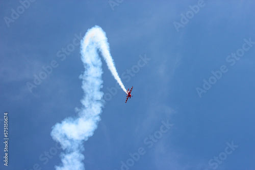 Single small jet with white smoke performing at airshow.