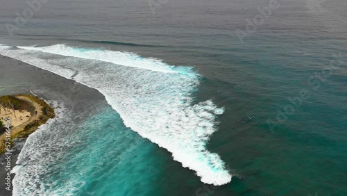 Aerial Panning Shot Of Ocean Waves Splashing Towards Island - Thulusdhoo, Maldives photo