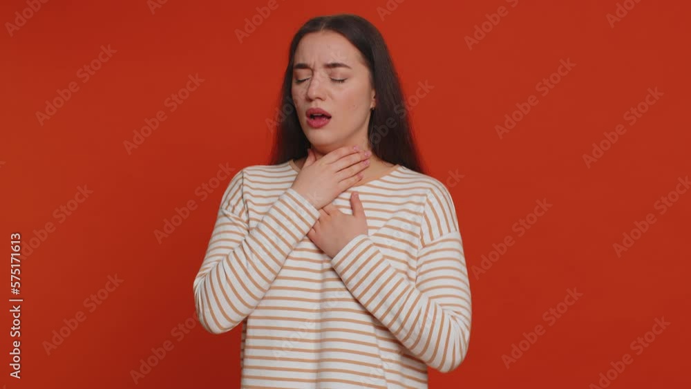 Unhealthy pretty woman coughing covering mouth with hand, feeling sick, allergy or viral infection symptoms, coronavirus covid-19 pandemic. Young adult girl isolated alone on red studio background Unhealthy pretty woman coughing covering mouth with hand, feeling sick, allergy or viral infection symptoms, coronavirus covid-19 pandemic. Young adult girl isolated alone on red studio background