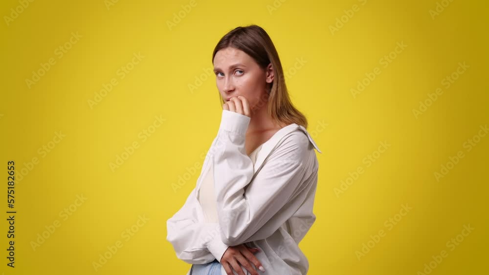 4k video of girl with thoughtful facial expression on yellow background. 4k video of girl with thoughtful facial expression on yellow background.