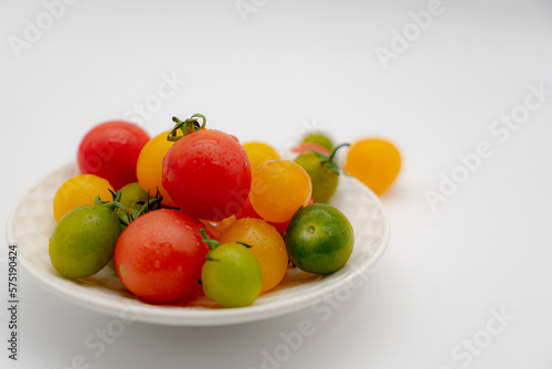 a dish of fresh cherry tomato on white background