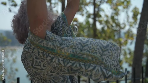 A young lady with purple hair dances with passion in a beautiful dress