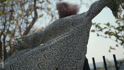 In this video, a young woman in a pink dress dances in the background.