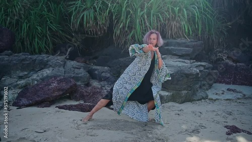 A young European woman with purple hair moves in a dance. Slow motion video