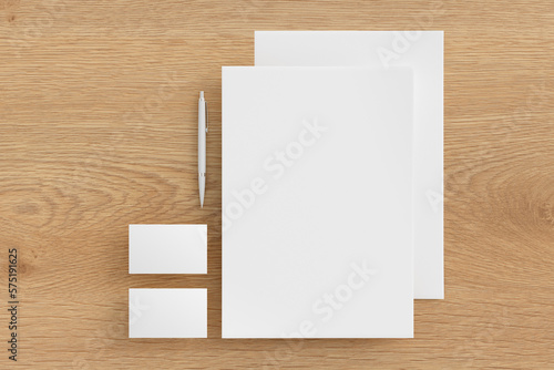 Blank corporate stationery set mockup with sheets of office paper, business cards and pen on wooden background. Branding mock up. View directly above