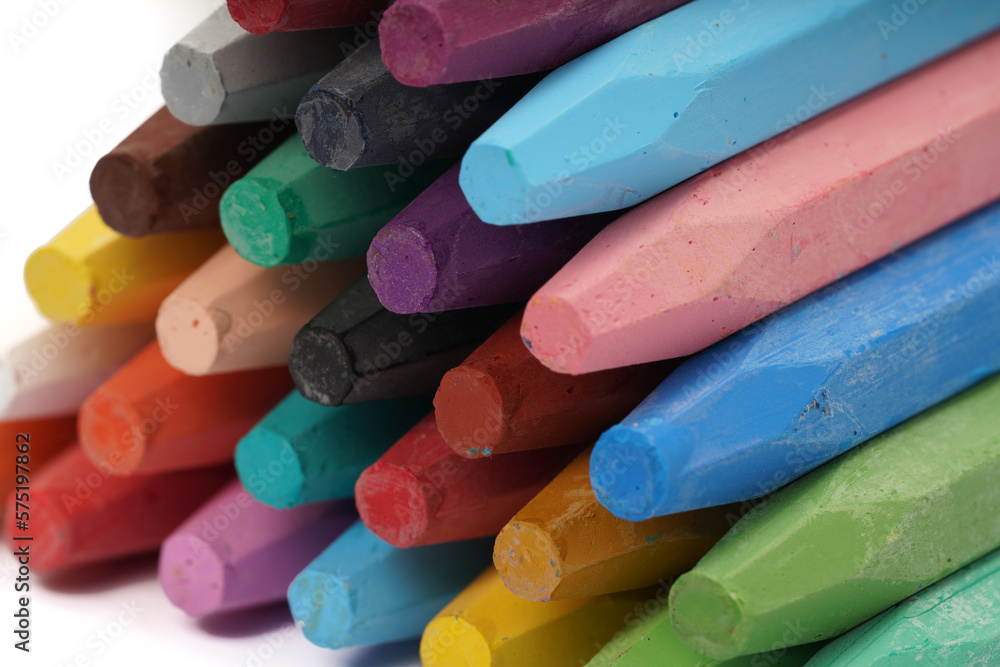 A pile of colorful oil pastels on a white background A pile of colorful oil pastels on a white background