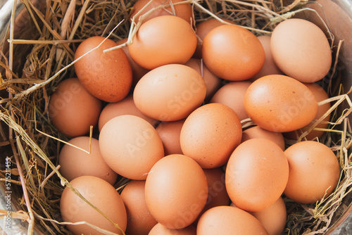 A pile of eggs in a straw-lined bowl.