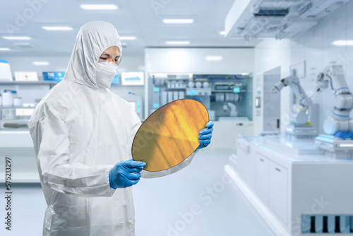 Worker or engineer wears medical protective suit or white coverall suit with silicon wafer photo