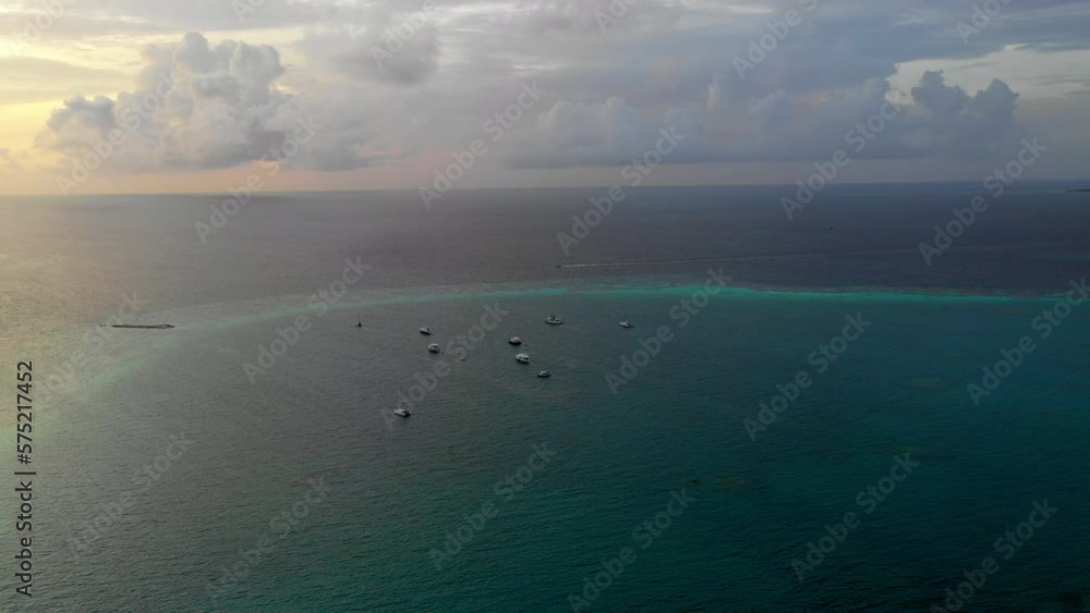 Aerial Panning Scenic Shot Of Motorboats Moored On Sea Under Cloudy Sky During Sunset - Thulusdhoo, Maldives Aerial Panning Scenic Shot Of Motorboats Moored On Sea Under Cloudy Sky During Sunset - Thulusdhoo, Maldives