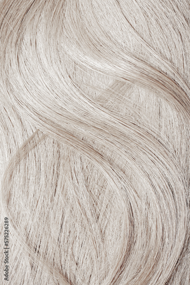 Naklejka premium Blond hair close-up as a background. Women's long blonde hair. Beautifully styled wavy shiny curls. Hair coloring. Hairdressing procedures, extension. White hair