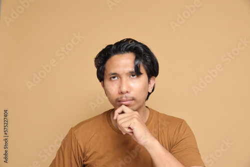 Asian male with messy hair expressing multiple emotion over plain background. © Azfar.arts