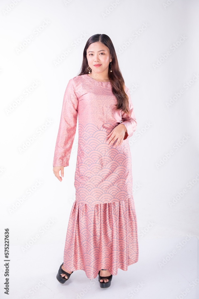 A portrait of a young Indonesian lady looking beautiful wearing traditional Malaysian or Indonesian wear isolated on a white background. Idul Fitri fashion concept. A portrait of a young Indonesian lady looking beautiful wearing traditional Malaysian or Indonesian wear isolated on a white background. Idul Fitri fashion concept.