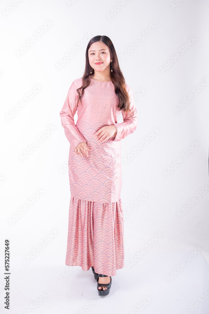 A portrait of a young Indonesian lady looking beautiful wearing traditional Malaysian or Indonesian wear isolated on a white background. Idul Fitri fashion concept.