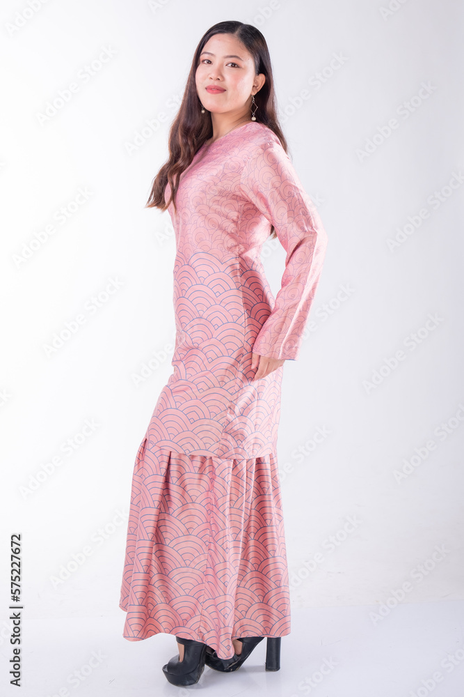 A portrait of a young Indonesian lady looking beautiful wearing traditional Malaysian or Indonesian wear isolated on a white background. Idul Fitri fashion concept. A portrait of a young Indonesian lady looking beautiful wearing traditional Malaysian or Indonesian wear isolated on a white background. Idul Fitri fashion concept.
