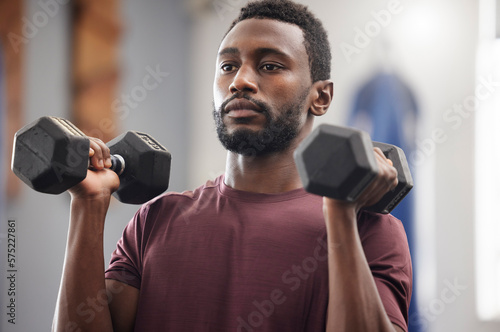 Black man, fitness and dumbbell exercise in gym for strong power, workout wellness and serious mindset. Bodybuilder, athlete and male training with weights for health, sports energy and muscle growth