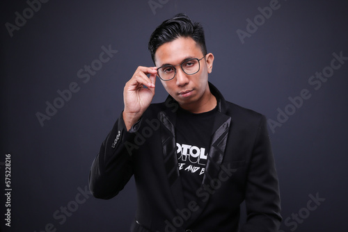 Asian male in corporate oufit over dark background. Office business concept.