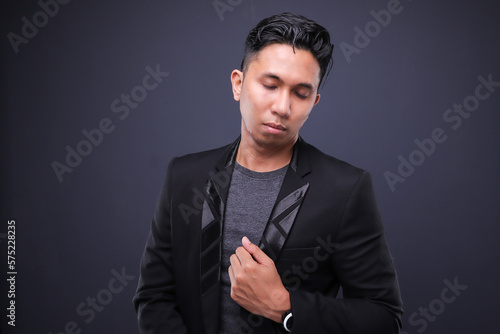 Asian male in corporate oufit over dark background.  Office business concept. photo