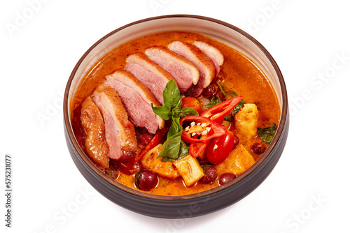 Red curry with roasted duck isolated on white background, this food contains such as red curry paste, chili, tomato and pineapple.