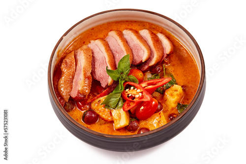 Red curry with roasted duck isolated on white background, this food contains such as red curry paste, chili, tomato and pineapple.
