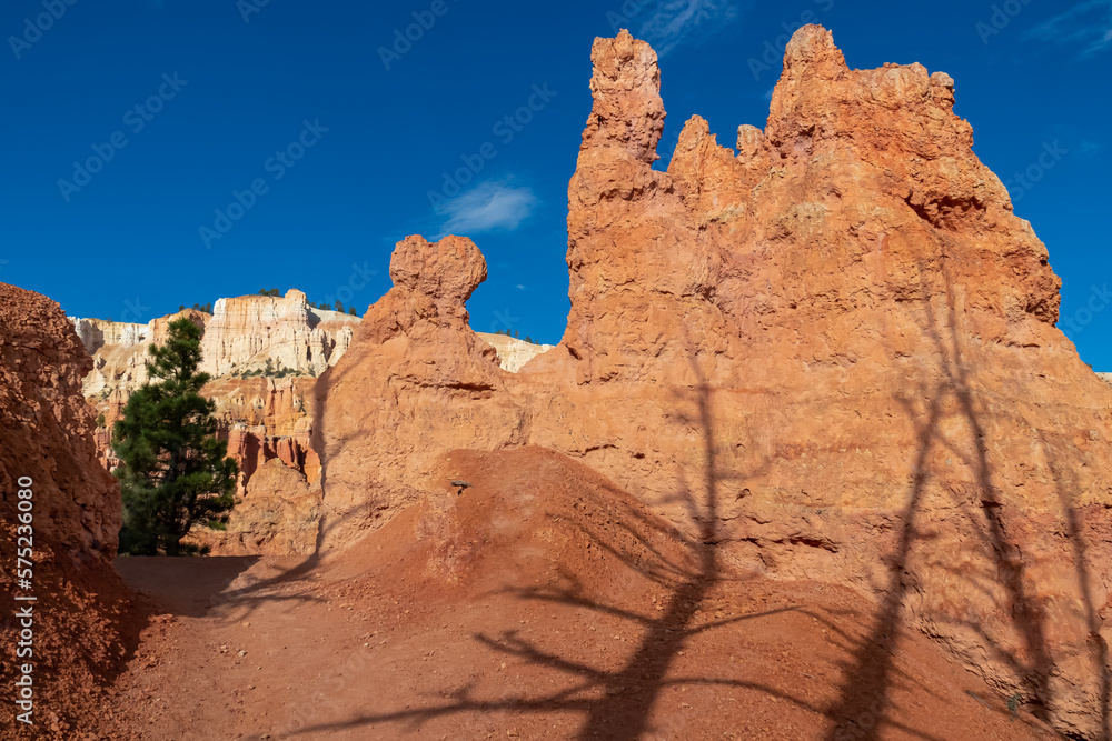 Scenic view of massive hoodoo sandstone rock formation towers on Queens Garden trail in Bryce Canyon National Park, Utah, USA. Barren desert landscape in natural amphitheatre on sunny summer day