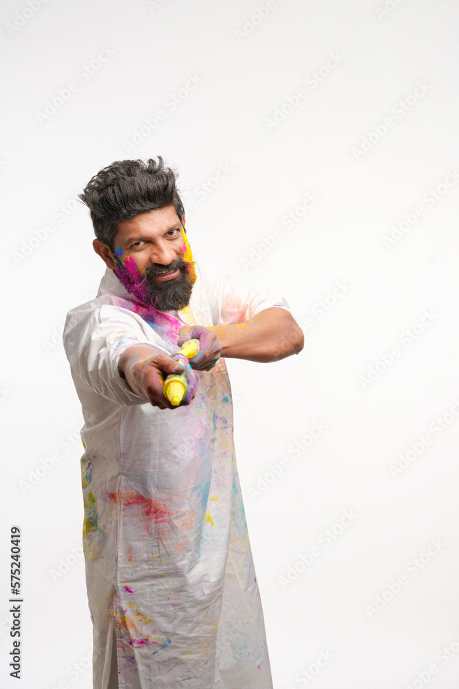Indian man using water gun on holi festival.