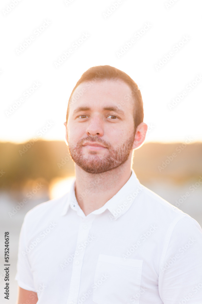 Fototapeta premium young bearded man in white shirt on beach in summer