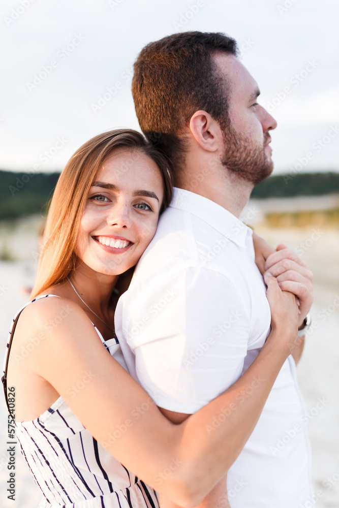 man and a woman are hugging on a sandy beach in summer man and a woman are hugging on a sandy beach in summer